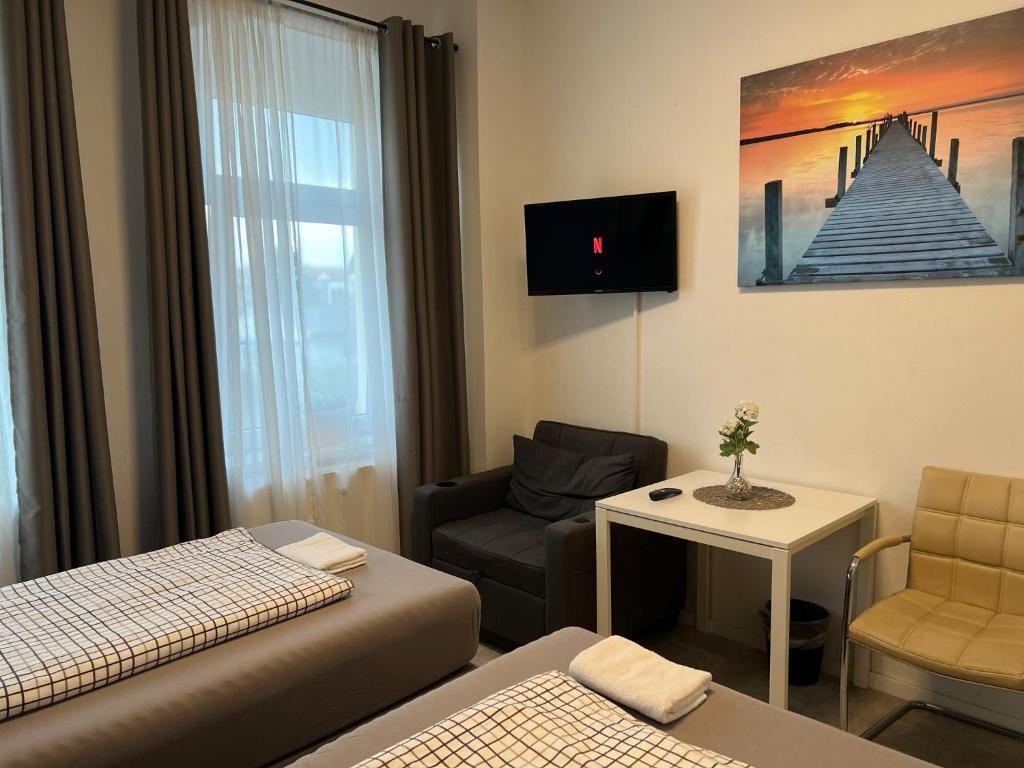 Doppelzimmer mit Sitzecke, TV und großem Fenster