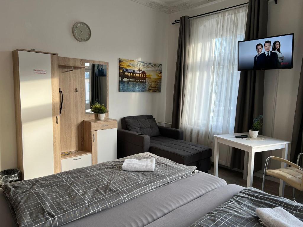 Komfortzimmer mit Kleiderschrank, Loungesessel und Smart-TV